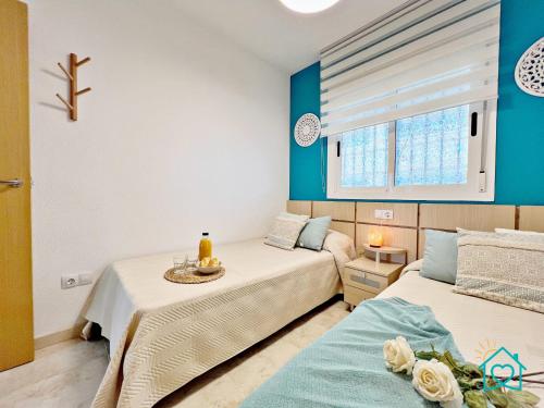 two beds in a room with blue walls at Retiro Zen en Tu Rincón Mediterráneo in Oropesa del Mar
