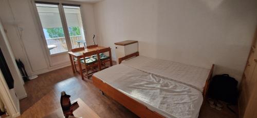 une chambre avec un lit, un bureau et une fenêtre dans l'établissement Appartement avec piscine et garage, au Grau-du-Roi