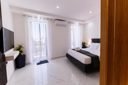 a bedroom with a bed and two windows at Stylish place in St Julians in St. Julianʼs