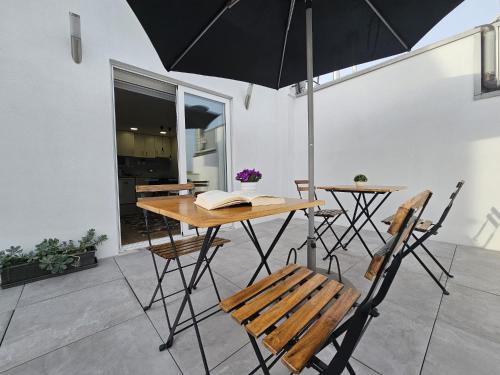 a table and chairs with an umbrella on a patio at Fascinante Orbita Apartments in Vila Nova de Famalicão