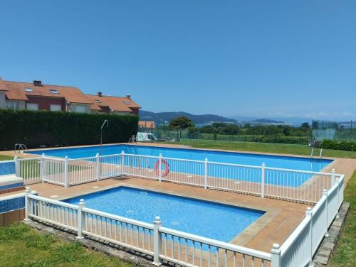 a swimming pool with a white fence around it at Chalet jardin privado, Piscina Comunit, Max 10 pers in Sanxenxo