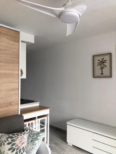 - un salon blanc avec un ventilateur de plafond dans l'établissement Studio Cosy + parking privé, à Cavalaire-sur-Mer