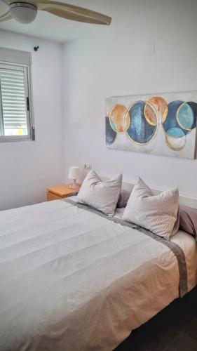 a bedroom with a bed with a painting on the wall at Hello Piles Beach Javier in Piles