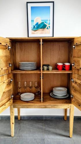 a wooden shelf with plates and dishes in it at Hello Piles Beach Javier in Piles