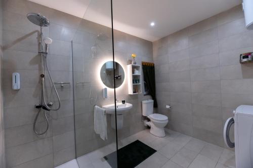 a bathroom with a shower and a toilet and a sink at Stylish place in St Julians in St. Julianʼs