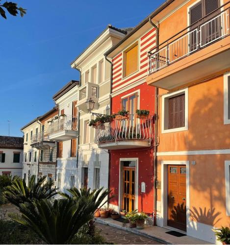 a row of colorful buildings with a balcony at Murè Hotel Numana in Numana