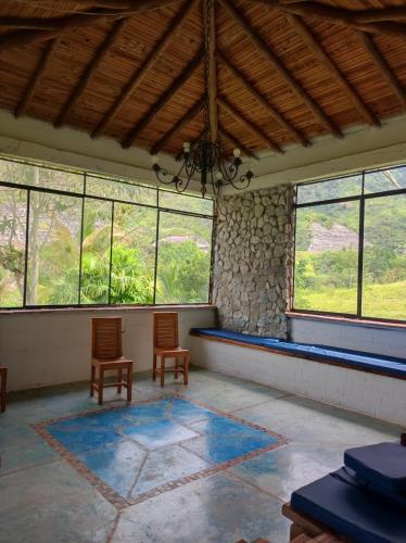 an empty room with two chairs and windows at Finca PiedrAlta Cisneros in Cisneros