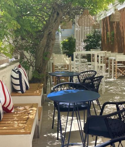 a patio with tables and chairs and a tree at Murè Hotel Numana in Numana