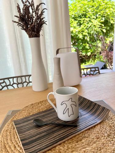 - une table avec une tasse de café et des vases dans l'établissement Chambre au calme l jardin I tram l Grenoble Nord St Egreve, à Saint-Égrève