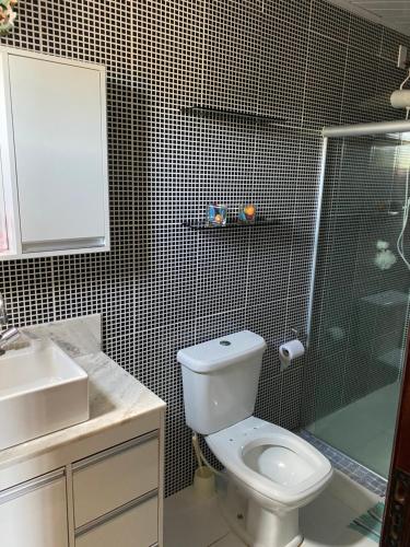 a bathroom with a toilet and a shower and a sink at Casa confortável com 3 quartos in Bonito