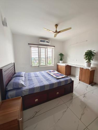 a bedroom with a bed and a ceiling fan at Luxurious Apartment with a pool and gym near Trivandrum railway station in Trivandrum