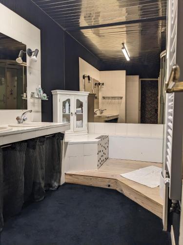 une grande salle de bain avec un lavabo et un miroir dans l'établissement Au dessus des arcades, à Vic-Fezensac