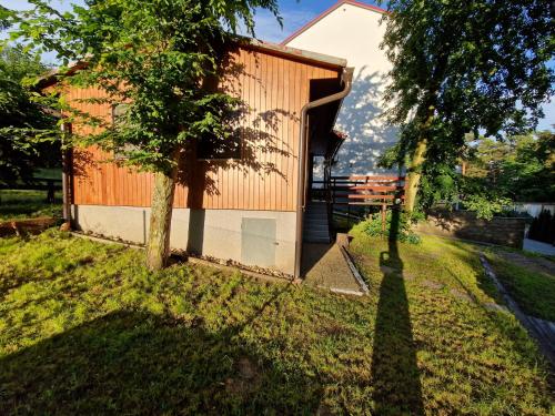 a house in the middle of a yard with a tree at Chata Vranovská pláž in Štítary