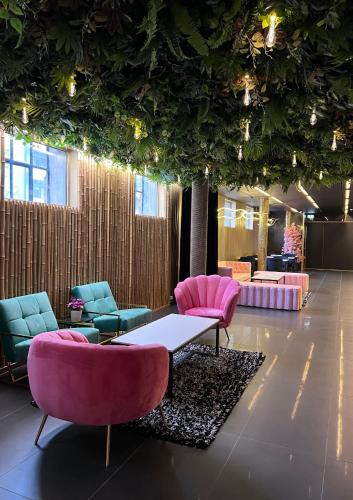 a lobby with pink and blue chairs and a table at Super Stay Hotel, Oslo in Oslo