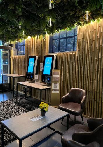 a waiting room with two monitors and a chair and a table at Super Stay Hotel, Oslo in Oslo