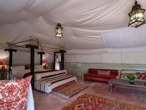 a bedroom with a bed and a couch in a room at Kasbah Agafay Hotel & Spa in El Karia