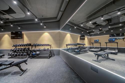 a gym with rows of exercise equipment in a room at Noru Hotel Malta - Adults Only Hotel in St Julian's