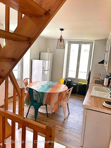 une cuisine avec une table et des chaises dans une pièce dans l'établissement Superbe duplex cœur de ville 3 étoiles, à Jonzac
