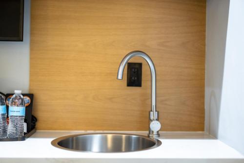 a stainless steel sink in a kitchen with a wooden wall at Infinity Hotel San Francisco, Tapestry Collection by Hilton in San Francisco