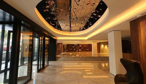 a lobby with a chandelier in a building at Excelente! Vista al mar con cochera y amenities gimnasio, play room y pileta no climatizada in Mar del Plata