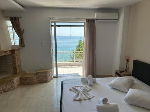 a bedroom with a bed with a view of the ocean at Aqua Apartments in Loutra Oraias Elenis