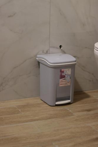 a white trash can in a bathroom next to a toilet at Vila Bajrami in Vlorë