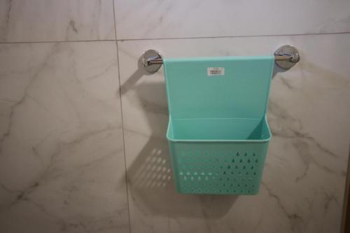 a blue basket hanging on a wall in a bathroom at Vila Bajrami in Vlorë