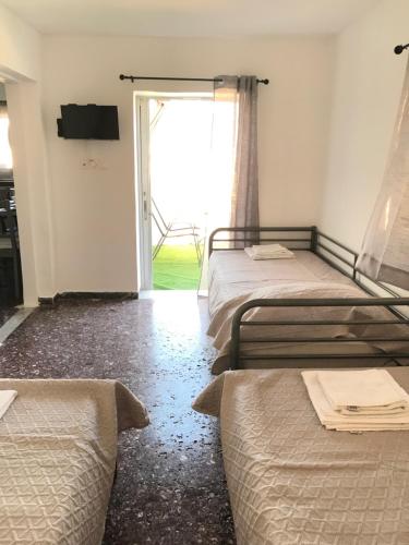 a bedroom with two beds and a door to a yard at Kuburno Roof in Kos Town