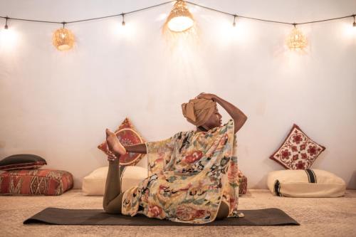 a woman sitting on the floor doing yoga in a room at Hotel Casa Hormiga in Bacalar