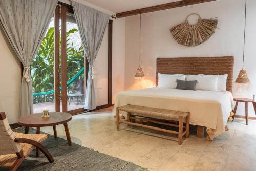 a bedroom with a bed and a large window at Hotel Casa Hormiga in Bacalar