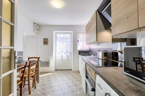une cuisine avec des armoires blanches et une table et des chaises dans l'établissement Querry Pigeon - maeva Home - Maison 3 pièces 6 personnes spacieuse - Prestige - Super Home MAE-8904, à Talmont-Saint-Hilaire