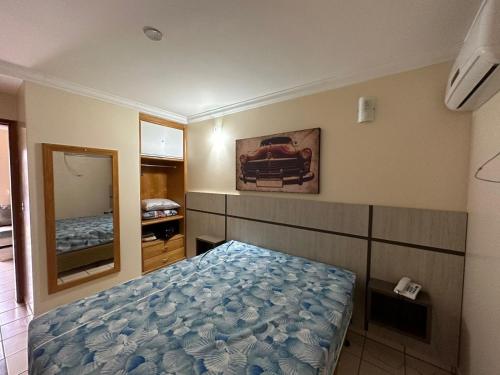 Schlafzimmer mit einem Bett und einem Spiegel in der Unterkunft Condomínio diRoma Internacional Resorts in Caldas Novas