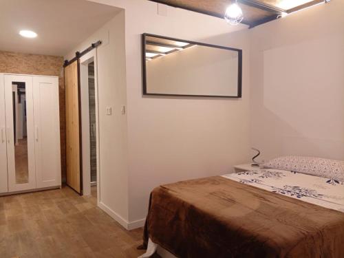 Un dormitorio con una cama y un espejo en la pared. en Estudios 71 Sardinero RH - Santander, en Santander