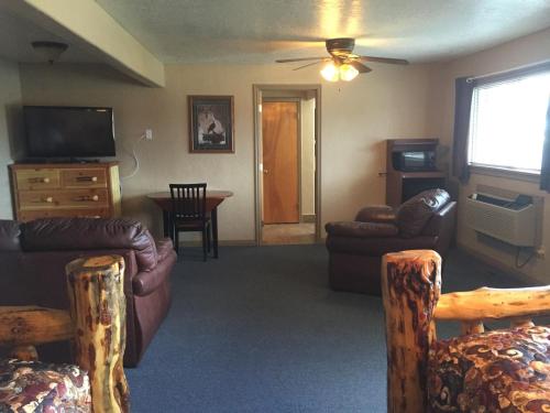 a living room with leather furniture and a television at Harrison Inn in Duchesne