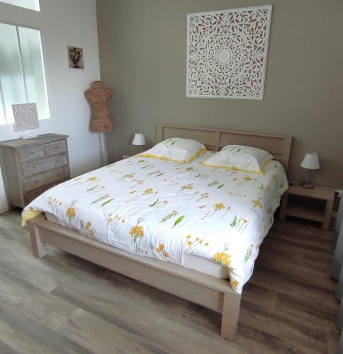 une chambre avec un lit avec une couette blanche dans l'établissement Gîte 4 pers L'Ainstant Présent, à Ambérieux-en-Dombes