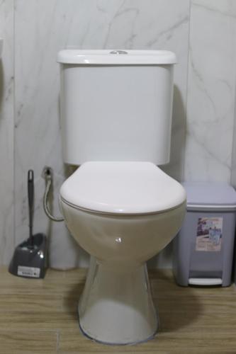 a white toilet sitting in a bathroom next to a trash can at Vila Bajrami in Vlorë