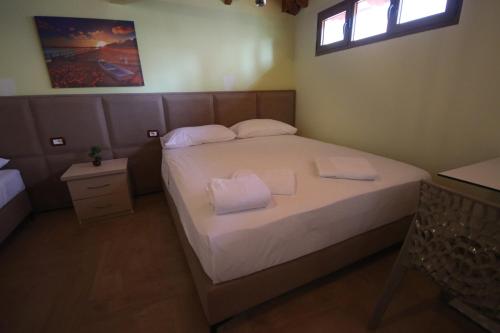 a bedroom with a bed with two towels on it at Vila Bajrami in Vlorë