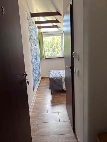 a hallway with a room with a bed and a window at Agroturystyka Karuna - Ajurweda i Joga - w Końskim Dworze in Oborniki Śląskie