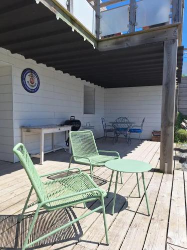 un patio avec deux chaises et une table sur une terrasse dans l'établissement Appartement moderne avec terrasse - proche mer, à Agon-Coutainville