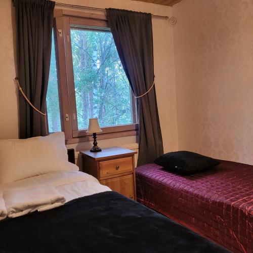 a bedroom with two beds and a window at Kotimajoitus Noora in Pori