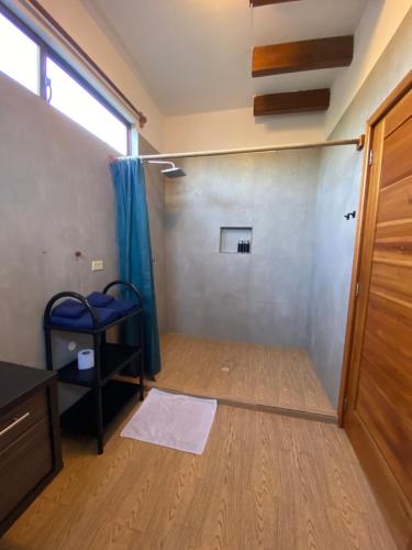 um quarto vazio com uma porta e um quarto com piso de madeira em Black Pearl em Puerto Villamil