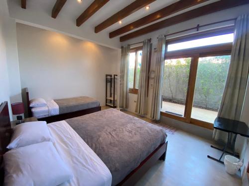 um quarto com 2 camas e uma grande janela em Black Pearl em Puerto Villamil