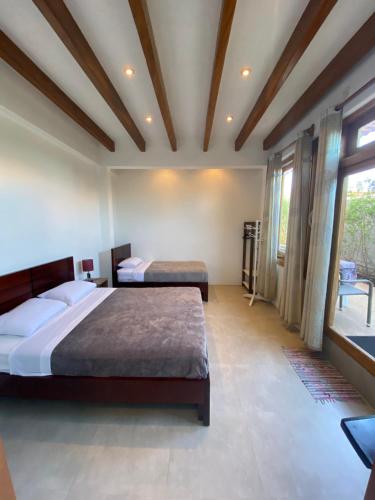 a bedroom with two beds and a large window at Black Pearl in Puerto Villamil