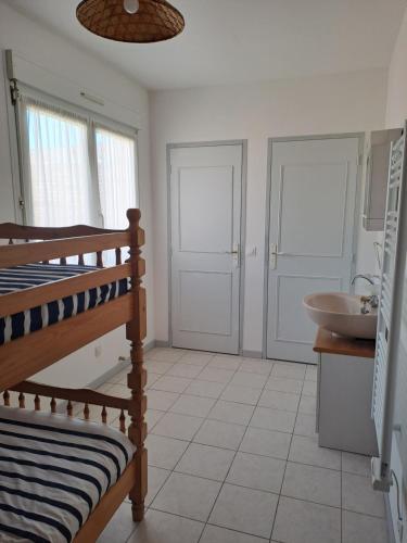 La salle de bains est pourvue de lits superposés et d'un lavabo. dans l'établissement L'Oustal de Provence, à Sète