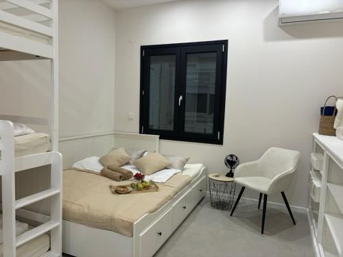 a white bedroom with a bed and a window at EvA OMMM in Limenas