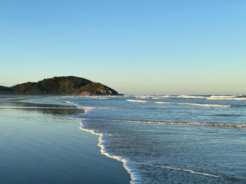 a sandy beach with waves in the ocean at Pousada Bela Vista in Ilha do Mel