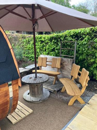 a patio with a table and chairs and an umbrella at Terrier Ovifat - logement familial Nature et Sauna in Ovifat