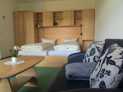 ein Schlafzimmer mit einem Bett, einem Sofa und einem Tisch in der Unterkunft Sonnenhof in Bad Elster