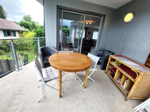 une table et des chaises en bois sur une terrasse dans l'établissement Résidence Villa Neree - Très fonctionnel, bien agencé, au Bord du lac ! MAE-6404, à Aix-les-Bains