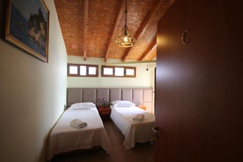 a room with two beds with white sheets at Vila Bajrami in Vlorë